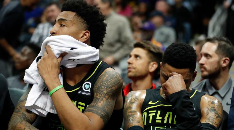 Atlanta Hawks guard Kent Bazemore (right), and John Collins sit on the bench in the finals minutes in loss against the Los Angeles Lakers Monday, Feb. 26, 2018, in Atlanta.