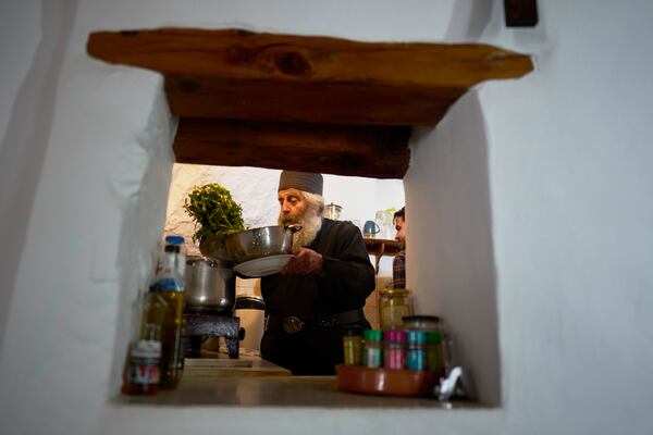Orthodox Christian monk Father Spyridon of Amorgos, cooks in the kitchen of the Monastery of Panagia Hozoviotissa, in Amorgos island, on Monday, March 24, 2025. (AP Photo/Petros Giannakouris)