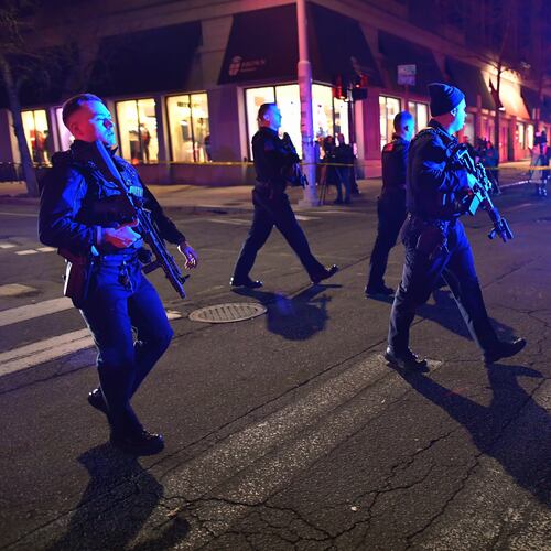 Law enforcement officials carry rifles while walking on a street in a neighborhood near Brown University in Providence, R.I., on Saturday, Dec. 13, 2025 during the investigation of a shooting. (AP Photo/Steven Senne)