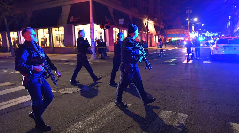 Law enforcement officials carry rifles while walking on a street in a neighborhood near Brown University in Providence, R.I., on Saturday, Dec. 13, 2025 during the investigation of a shooting. (AP Photo/Steven Senne)
