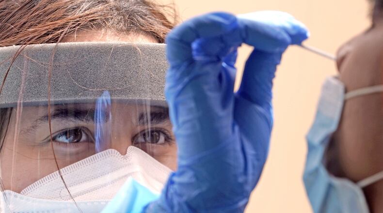 Medical student Kimberly Olivares, left, takes a sample from a patient at a free COVID-19 testing site provided by United Memorial Medical Center, Sunday, June 28, 2020, in Houston, Texas. Confirmed cases of the coronavirus in Texas continue to surge. (AP Photo/David J. Phillip)