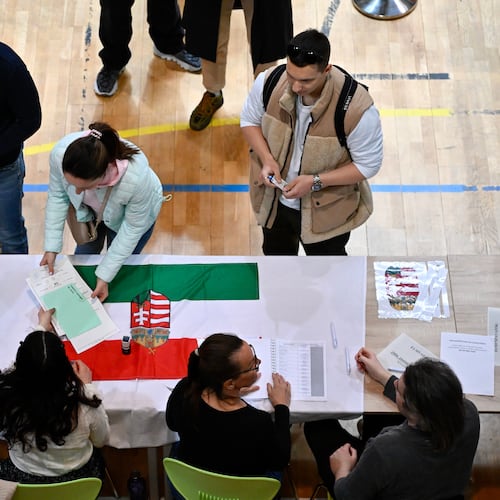 A woman takes ballots at a polling station during the Hungarian parliamentary election in Budapest, Hungary, Sunday, April 12, 2026. (AP Photo/Denes Erdos)