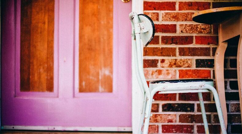 A woman died after being hit by a stray bullet as she had breakfast on her front porch, police said.