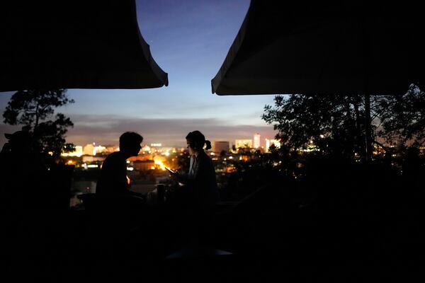 A young couple sits on the terrace of a closed bar at a viewpoint overlooking Lisbon during a nationwide power outage, Monday, April 28, 2025. (AP Photo/Armando Franca)
