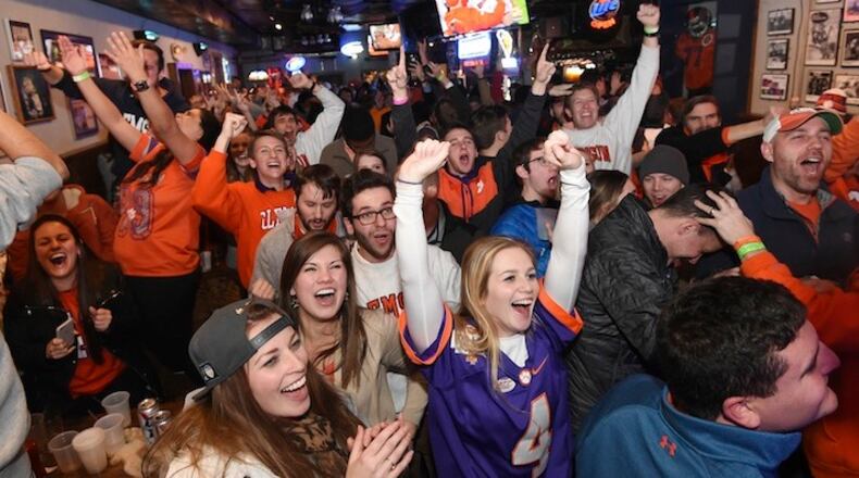 FILE - In this Jan. 9, 2017, file photo, Clemson fans celebrate in Clemson, S.C,, after a touchdown as they watch the broadcast of the NCAA college football playoff championship game between Clemson and Alabama. Hard-core college football fans across the country undoubtedly will be tuned in for the College Football Playoff. But what about casual fans outside SEC, ACC and Big 12 country? With the Pac-12 and Big Ten not represented in the four-team playoff, a TV sports viewership analyst said interest could be tempered on the West Coast, upper Midwest and Northeast. (AP Photo/Rainier Ehrhardt, File)