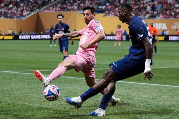 Inter Miami's Lionel Messi and Paris Saint-Germain's Willian Pacho compete for the ball during the Club World Cup round of 16 soccer match between PSG and Inter Miami in Atlanta, Sunday, June 29, 2025. (AP Photo/Mike Stewart)
