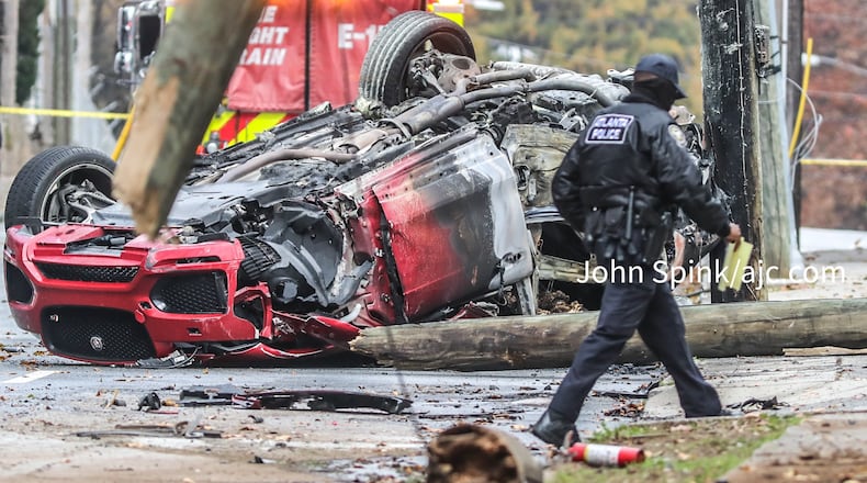 The wreckage of a red car remains Monday afternoon at the scene of a fiery crash on Juniper Street in Midtown.