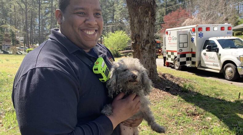 East Point Firefighter Gerrell Lilly holds Frisky the dog after she was left unconscious during a home fire caused by overcooked spaghetti in the microwave on March 20, 2019.