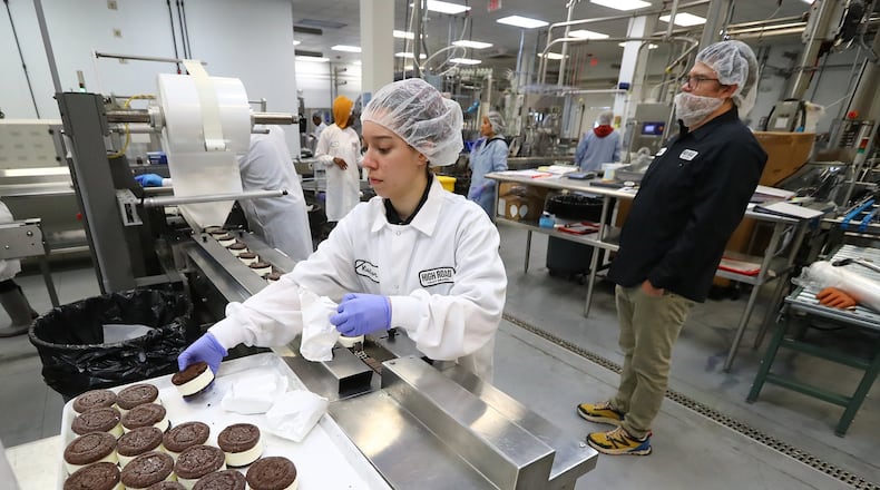 Owner Keith Schroeder (right) maintains social distance while walking the floor of his plant watching over production while Marianna Kunzmann works on ice cream sandwiches for Whole Foods at High Road Ice Cream on Tuesday, March 31, 2020, in Marietta. Curtis Compton ccompton@ajc.com