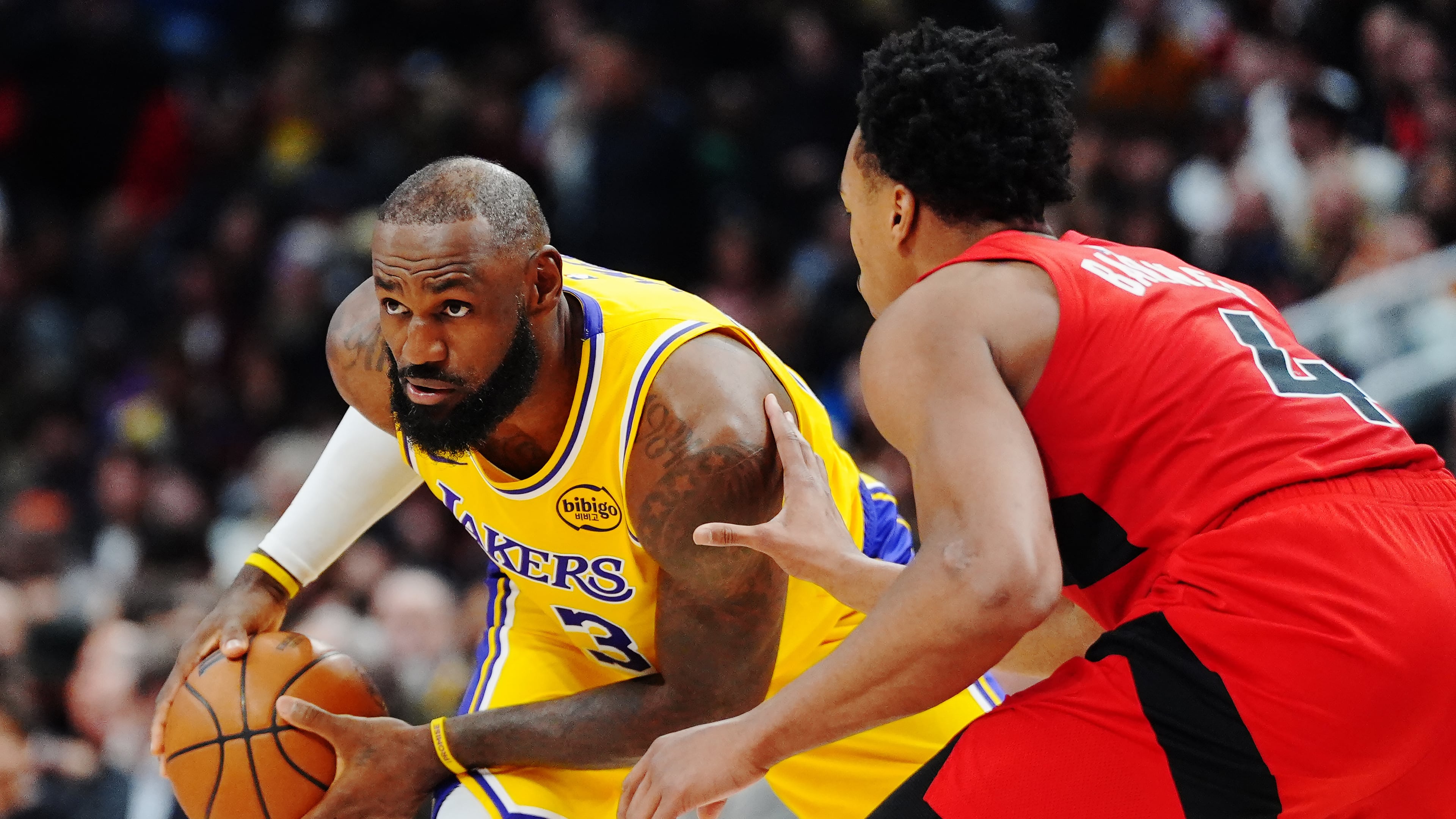 Los Angeles Lakers' LeBron James, left, is guarded by Toronto Raptors' Scottie Barnes (4) during second-half NBA basketball game action in Toronto, Thursday, Dec. 4, 2025. (Frank Gunn/The Canadian Press via AP)