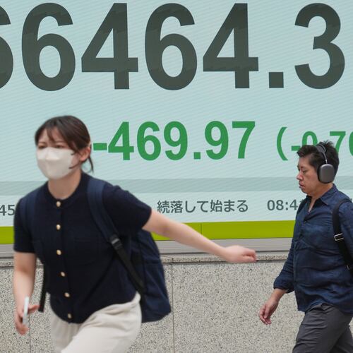 People walk in front of an electronic stock board showing Japan's Nikkei index at a securities firm Tuesday, June 2, 2026, in Tokyo. (AP Photo/Eugene Hoshiko)