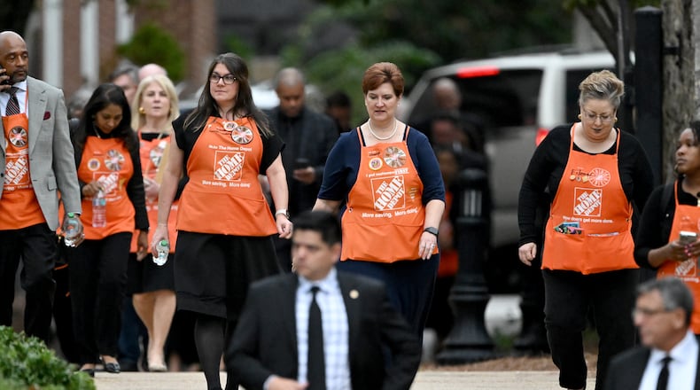 Mourners wearing Home Depot aprons leave the funeral service for Bernie Marcus at The Temple, Thursday, November 7, 2024, in Atlanta. Marcus, who co-founded Home Depot, died Monday at his Boca Raton home. He was 95.  (Hyosub Shin / AJC)
