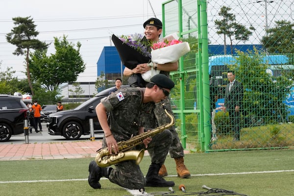FILE - K-pop band BTS members RM, bottom, and V react after being discharged from a mandatory military service in Chuncheon, South Korea, Tuesday, June 10, 2025. (AP Photo/Ahn Young-joon, File)