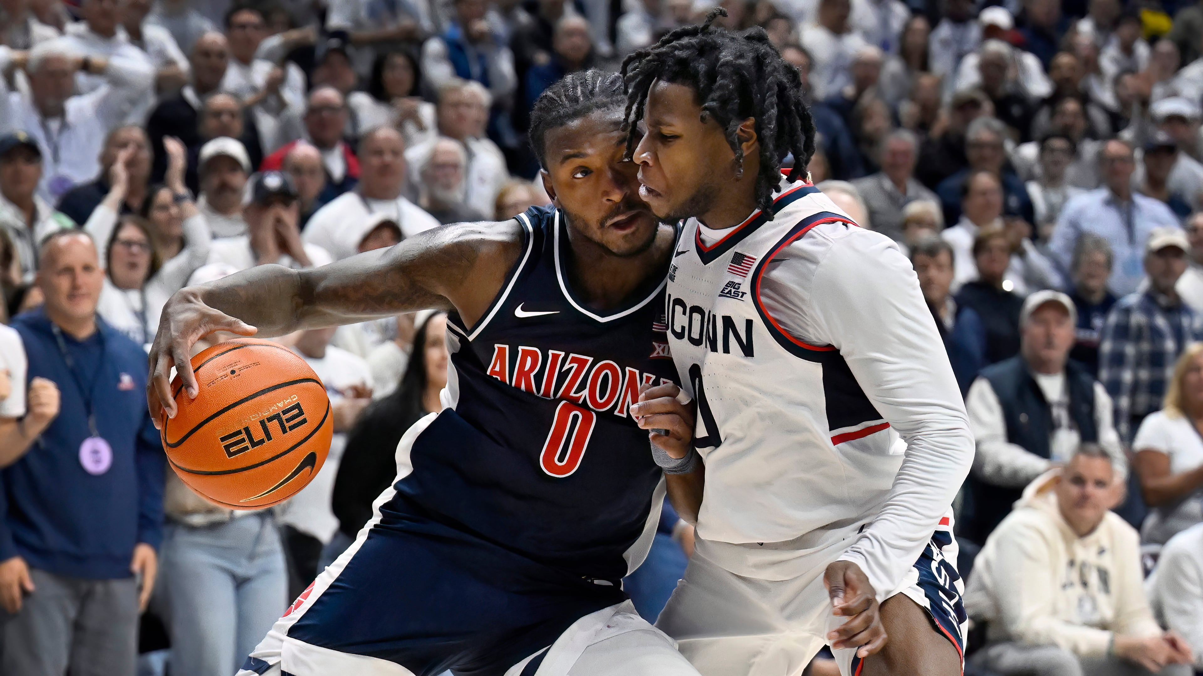 Arizona guard Jaden Bradley (0) is guarded by UConn guard Malachi Smith in the second half of an NCAA college basketball game, Wednesday, Nov. 19, 2025, in Storrs, Conn. (AP Photo/Jessica Hill)