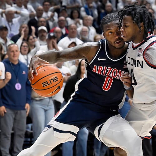 Arizona guard Jaden Bradley (0) is guarded by UConn guard Malachi Smith in the second half of an NCAA college basketball game, Wednesday, Nov. 19, 2025, in Storrs, Conn. (AP Photo/Jessica Hill)