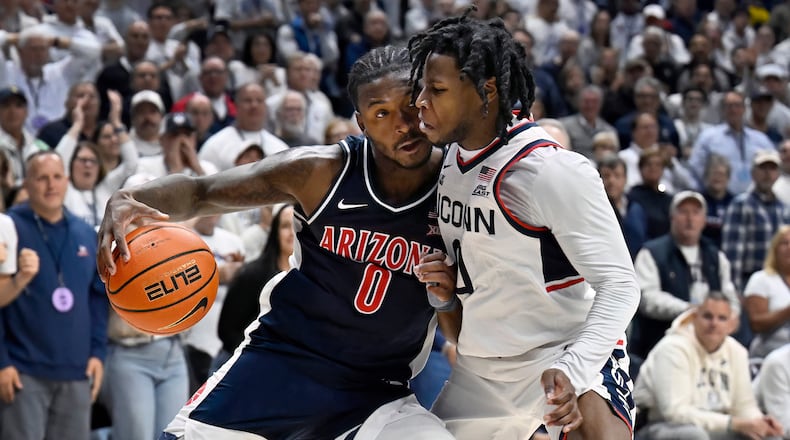 Arizona guard Jaden Bradley (0) is guarded by UConn guard Malachi Smith in the second half of an NCAA college basketball game, Wednesday, Nov. 19, 2025, in Storrs, Conn. (AP Photo/Jessica Hill)
