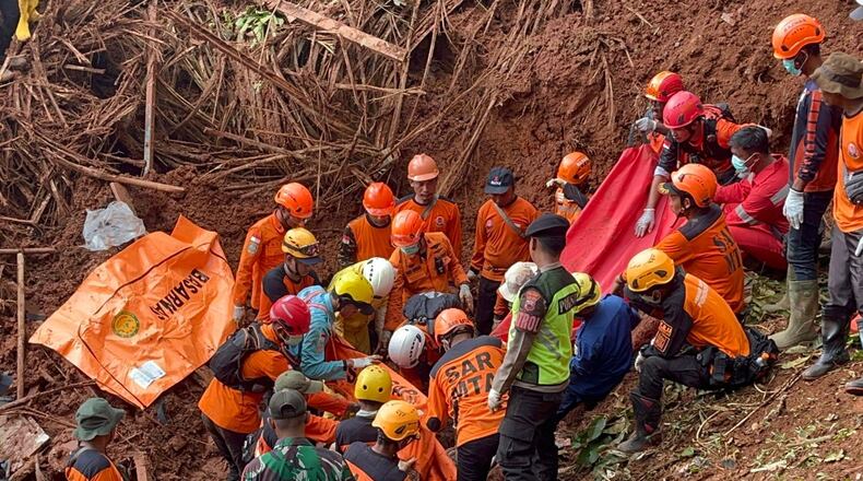 In this photo released by the Indonesian National Search and Rescue Agency (BASARNAS) on Monday, Nov. 17, 2025, rescuers recover a victim of a landslide in Cilacap, Indonesia. (BASARNAS via AP)