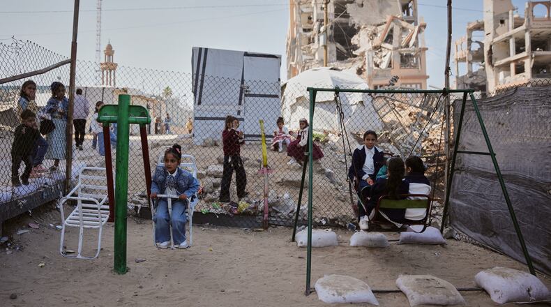 FILE - Displaced Palestinian children play on a swing at a tent camp as they mark the Muslim holiday of Eid al-Fitr in Gaza City, Friday, March 20, 2026. (AP Photo/Abdel Kareem Hana, file)