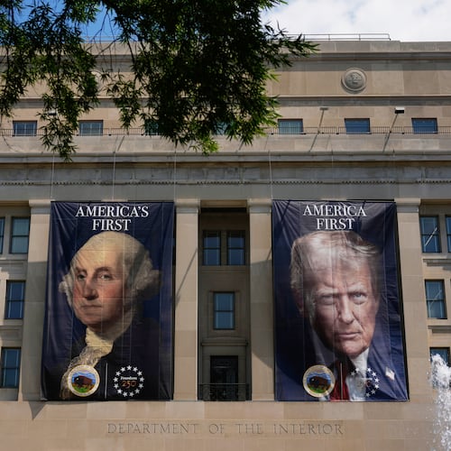 Banners, one of President George Washington that reads "America's First," left, and another of President Donald Trump that reads, "America First," are pictured at the Department of the Interior, Thursday, June 25, 2026, in Washington. (AP Photo/Carolyn Kaster)