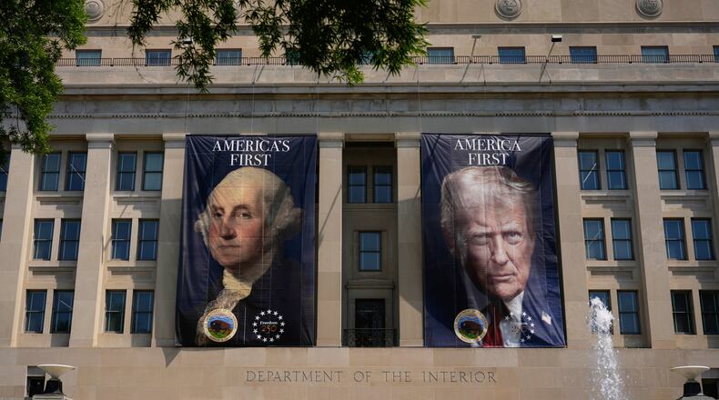 Banners, one of President George Washington that reads "America's First," left, and another of President Donald Trump that reads, "America First," are pictured at the Department of the Interior, Thursday, June 25, 2026, in Washington. (AP Photo/Carolyn Kaster)