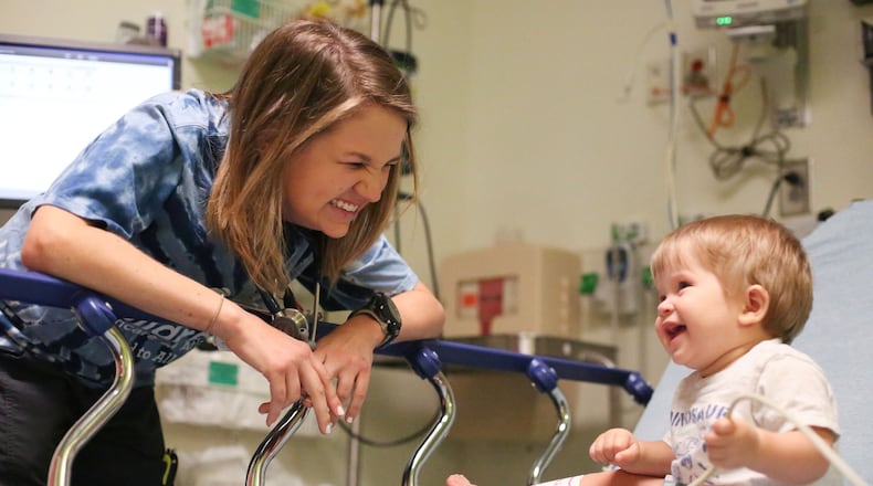 Amelia Ballard, a pediatric nurse at Children’s Healthcare of Atlanta’s Egleston location, treats her patient, Olen, who is 8 months old, in the emergency room on a recent morning. She received treatment at Children’s Healthcare of Atlanta, where she beat cancer twice before starting kindergarten. Now, she is fulfilling her childhood dream by working as a pediatric nurse at the same place she received treatment. EMILY JENKINS/ EJENKINS@AJC.COM