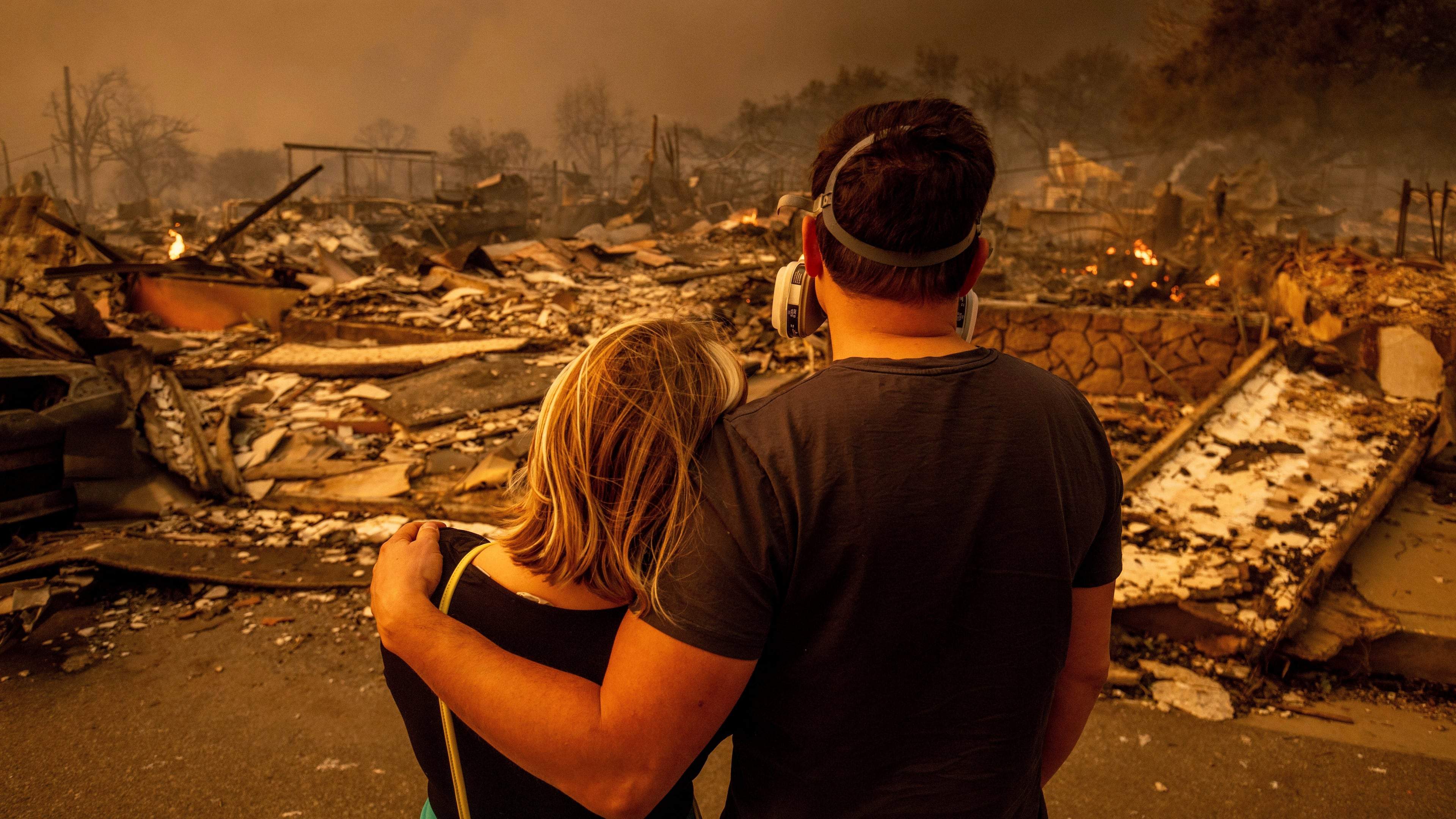 FILE - Megan Mantia, left, and her boyfriend Thomas, return to Mantia's fire-damaged home after the Eaton Fire swept through, Wednesday, Jan. 8, 2025 in Altadena, Calif. (AP Photo/Ethan Swope, File)