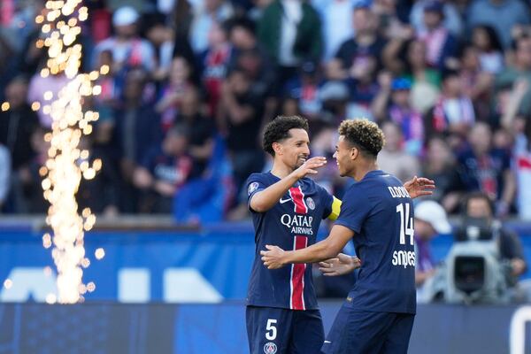 PSG's Marquinhos, left, and PSG's Desire Doue celebrate their victory at the French League One soccer match between Paris Saint-Germain and Angers at Parc des Princes stadium in Paris, Saturday, April 5, 2025. (AP Photo/Michel Euler)