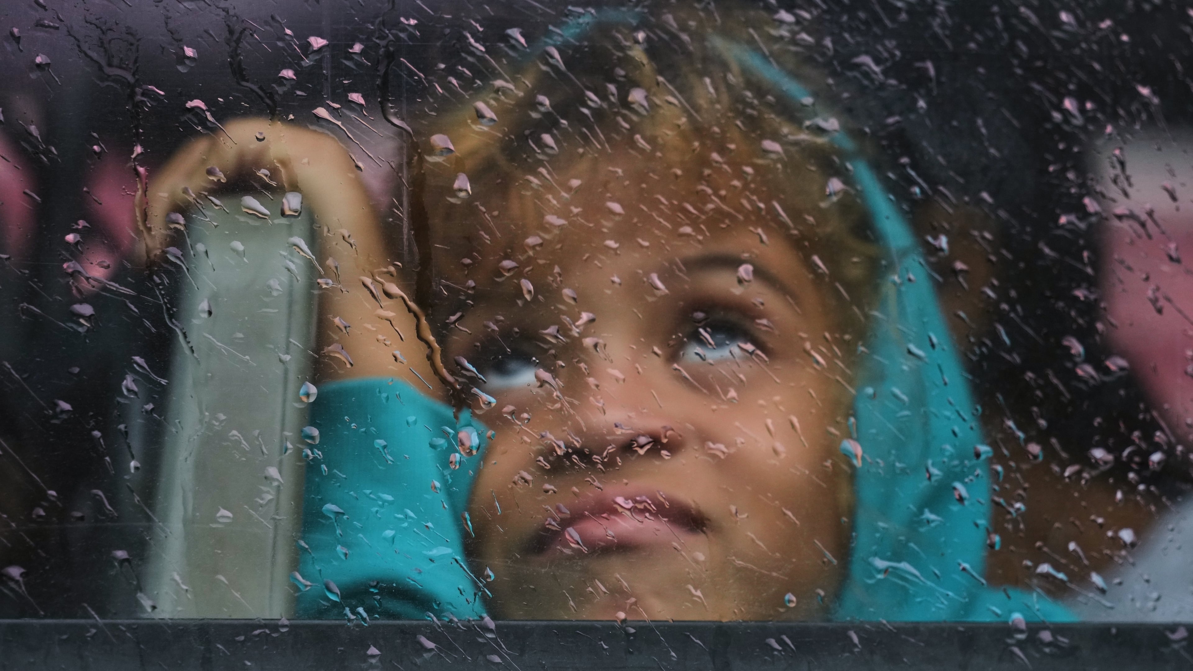 A girl looks out a rain-splattered bus window as she is evacuated before the arrival of Hurricane Melissa in Canizo, a community in Santiago de Cuba, Tuesday, Oct. 28, 2025. (AP Photo/Ramón Espinosa)