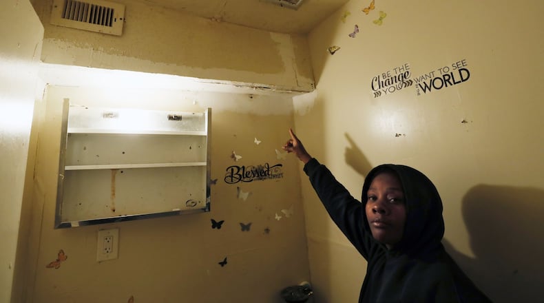 Forest Cove resident Madrika Gray shows where broken pipes leaked into her Atlanta apartment, damaging the walls and dripping water down through moldy vents. She and other tenants who have mold in their homes have no safety net in Georgia, where local and state laws do little to protect them. BOB ANDRES / BANDRES@AJC.COM