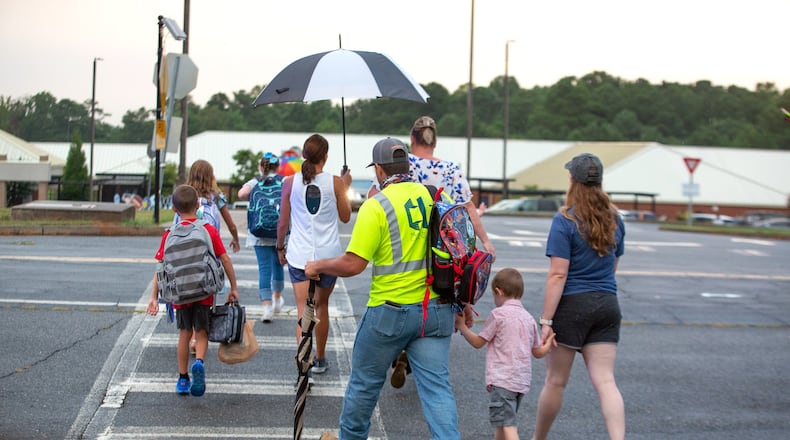 Parents walk their children to the entrance of Woodstock Elementary School in Cherokee County on the first day of school on August 3, 2020.  STEVE SCHAEFER FOR THE ATLANTA JOURNAL-CONSTITUTION