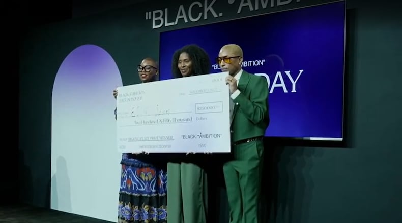 Maïré Bavarday-Rosa (center), co-founder and CEO of Atlanta-based logistics hub ECOMSPACES, stands with Felecia Hatcher (left), CEO of Black Ambition, and Pharrell Williams (right) after winning $250,000 at the Black Ambition Demo Day on Thursday, Nov. 9, 2023.