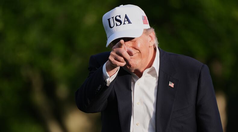 President Donald Trump gestures to reporters as he walks across the South Lawn of the White House, Friday, May 15, 2026, in Washington, on return from Beijing where he met with China's President Xi Jinping. (AP Photo/Jacquelyn Martin)