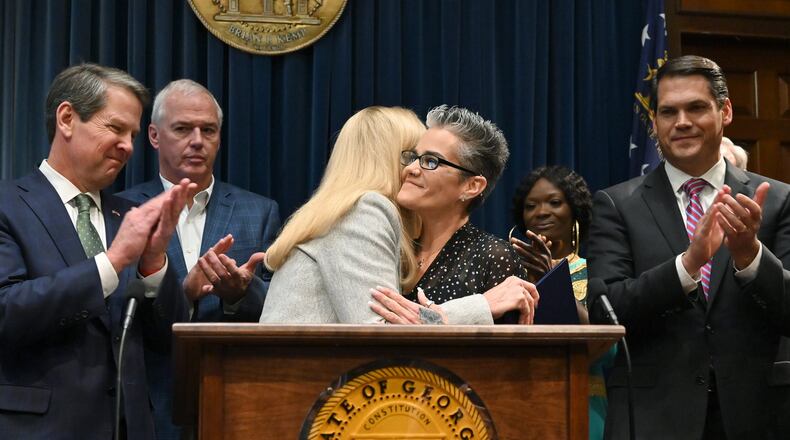 Nikki Burrell, center right, a victim of human trafficking, gets a hug from Georgia first lady Marty Kemp during a press conference Tuesday at the Capitol to announce legislative measures aimed at combating human trafficking. Gov. Brian Kemp, far left, has made the fight against human trafficking one of his top priorities for the legislative session that began last week. (Hyosub Shin / Hyosub.Shin@ajc.com)