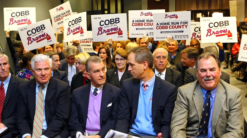 A SHOW OF SUPPORT--112613 MARIETTA:Braves GM Frank Wren (from left), Braves Team President John Schuerholz, Braves Executive Vice Presidents Derek Schiller and Mike Plant are backed up by a show of support while sitting on the front row at the opening of the Cobb County Board of Commissioners meeting to vote on the new Braves stadium on Tuesday, Nov. 26, 2013, in Marietta. CURTIS COMPTON /staff CCOMPTON@AJC.COM