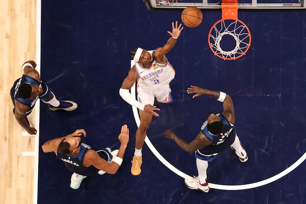Oklahoma City Thunder guard Shai Gilgeous-Alexander, middle, shoots the ball against the Minnesota Timberwolves during the first half of Game 3 of the Western Conference finals of the NBA basketball playoffs Saturday, May 24, 2025, in Minneapolis. (AP Photo/Matt Krohn)