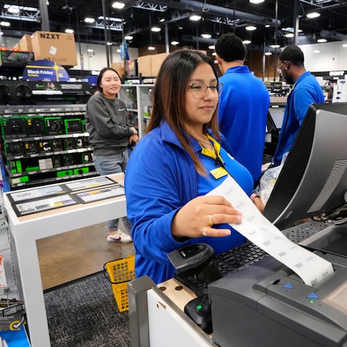 Abril Renteria, an Apple certified advisor, helps a customer check out after their purchase at a Best Buy store, Wednesday, Nov. 26, 2025, in Dallas. (AP Photo/Tony Gutierrez)