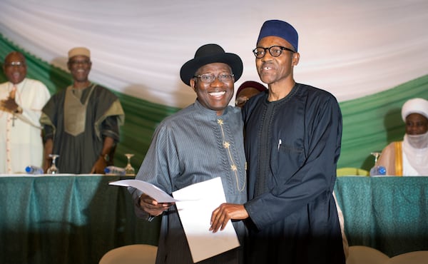 FILE - Nigeria's President Goodluck Jonathan, left, and opposition candidate Gen. Muhammadu Buhari, hug after signing a renewal of their pledge to hold peaceful elections, at a hotel in the capital Abuja, Nigeria Thursday, March 26, 2015. (AP Photo/Ben Curtis, File)
