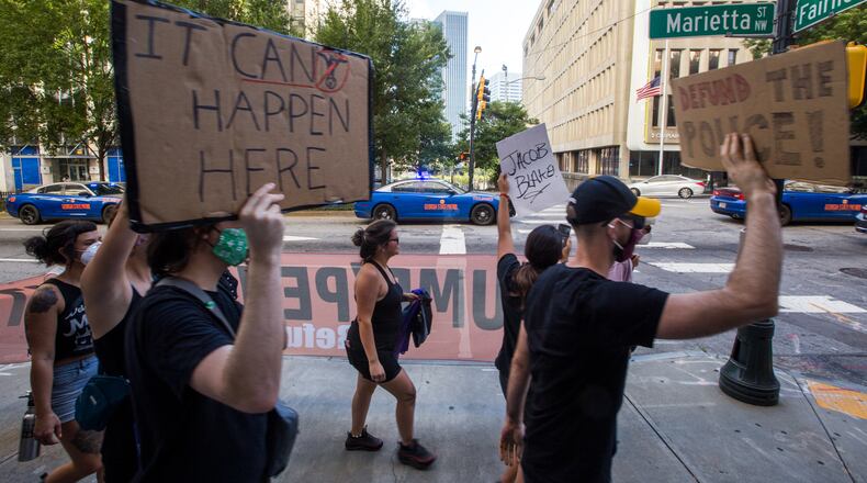 Protesters march past the Atlanta Police Department with heavy police presence as they march to the CNN Center on Saturday, September 5, 2020.  The protest started at Ebenezer Baptist Church as a political gathering and joined a Black Lives Matter protest at the CNN Center with a heavy police escort along the way. (Jenni Girtman for The Atlanta Journal-Constitution)
