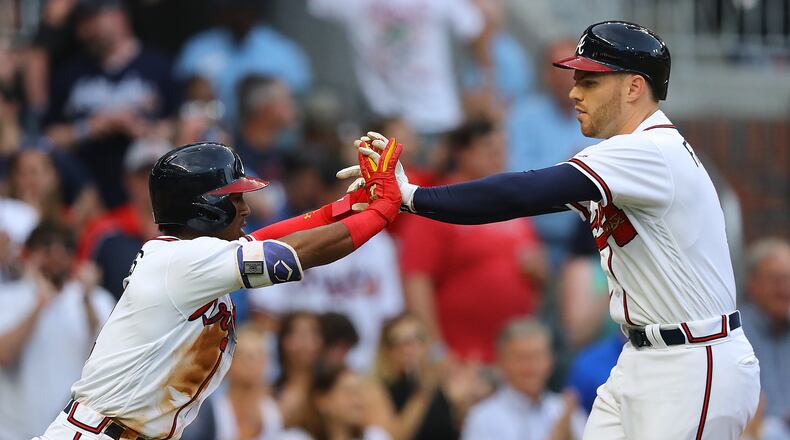 Freddie Freeman gets five from Ozzie Albies, hitting a 2-RBI home run for a 2-0 lead over the Giants during the first inning in MLB baseball game on Friday, May 4, 2018, in Atlanta.  Curtis Compton/ccompton@ajc.com