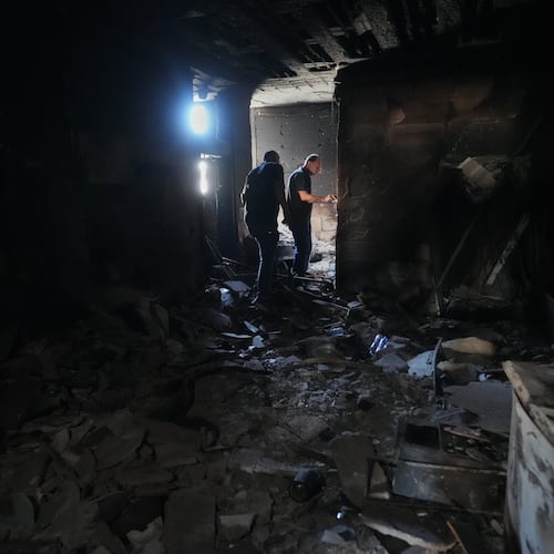 Resident Samih Haidar, right, inspects his burned apartment damaged in Israeli strikes in the southern port city of Tyre, Lebanon, Thursday, June 18, 2026. (AP Photo/Hassan Ammar)