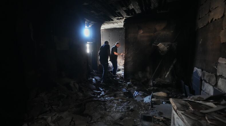 Resident Samih Haidar, right, inspects his burned apartment damaged in Israeli strikes in the southern port city of Tyre, Lebanon, Thursday, June 18, 2026. (AP Photo/Hassan Ammar)