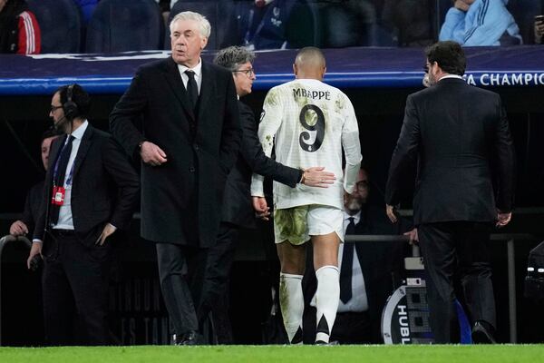 Real Madrid's Kylian Mbappe, center, leaves the field after sustaining an injury during the Champions League quarterfinals second leg soccer match between Real Madrid and Arsenal at the Santiago Bernabeu stadium in Madrid, Wednesday, April 16, 2025. (AP Photo/Bernat Armangue)