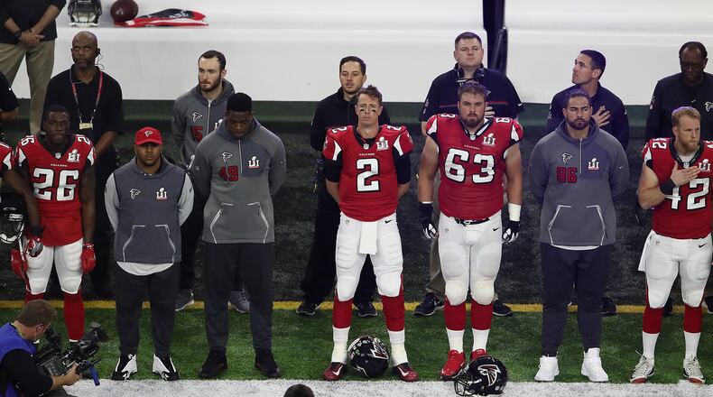 Matt Ryan #2 and Ben Garland #63 of the Falcons stand for the National Anthem prior to Super Bowl 51 against the Patriots at NRG Stadium on February 5, 2017 in Houston, Texas.