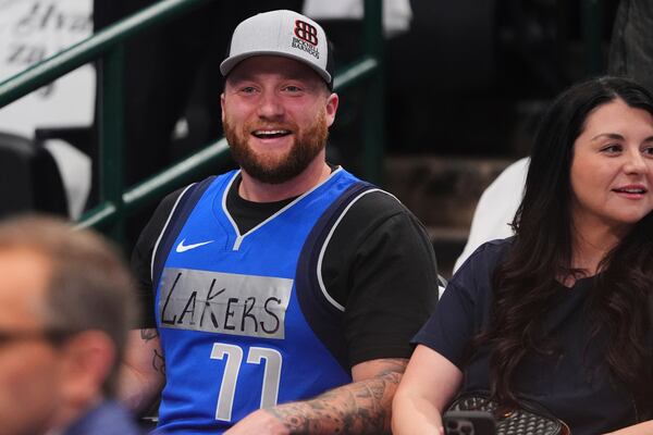 A fan wears a Dallas Mavericks jersey with tape and writing on it that reads "Lakers" and former player Luka Doncic's number on it during warmups before an NBA basketball game against the Los Angeles Lakers in Dallas, Wednesday, April 9, 2025. (AP Photo/LM Otero)