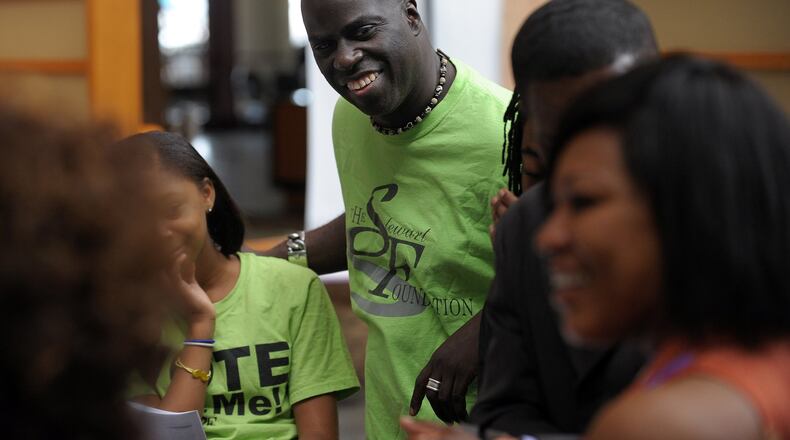 Poet Hank Stewart supervises youths at the Crowne Plaza Ravinia who were planning events for the Hank Stewart Foundation’s White Linen Affair fundraiser a few years ago in Atlanta. (David Tulis / AJC file photo)