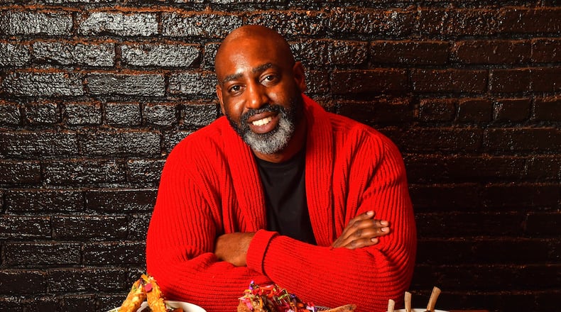 Sim Walker, owner of Apt. 4B in Buckhead, poses with a few of the restaurant's dishes: (from left) Coconut Seafood Curry, Fried Snapper with Pickled Vegetables, and Herb Crusted Lamb with Polenta. Styling by Rachel Levy / Chris Hunt for the AJC