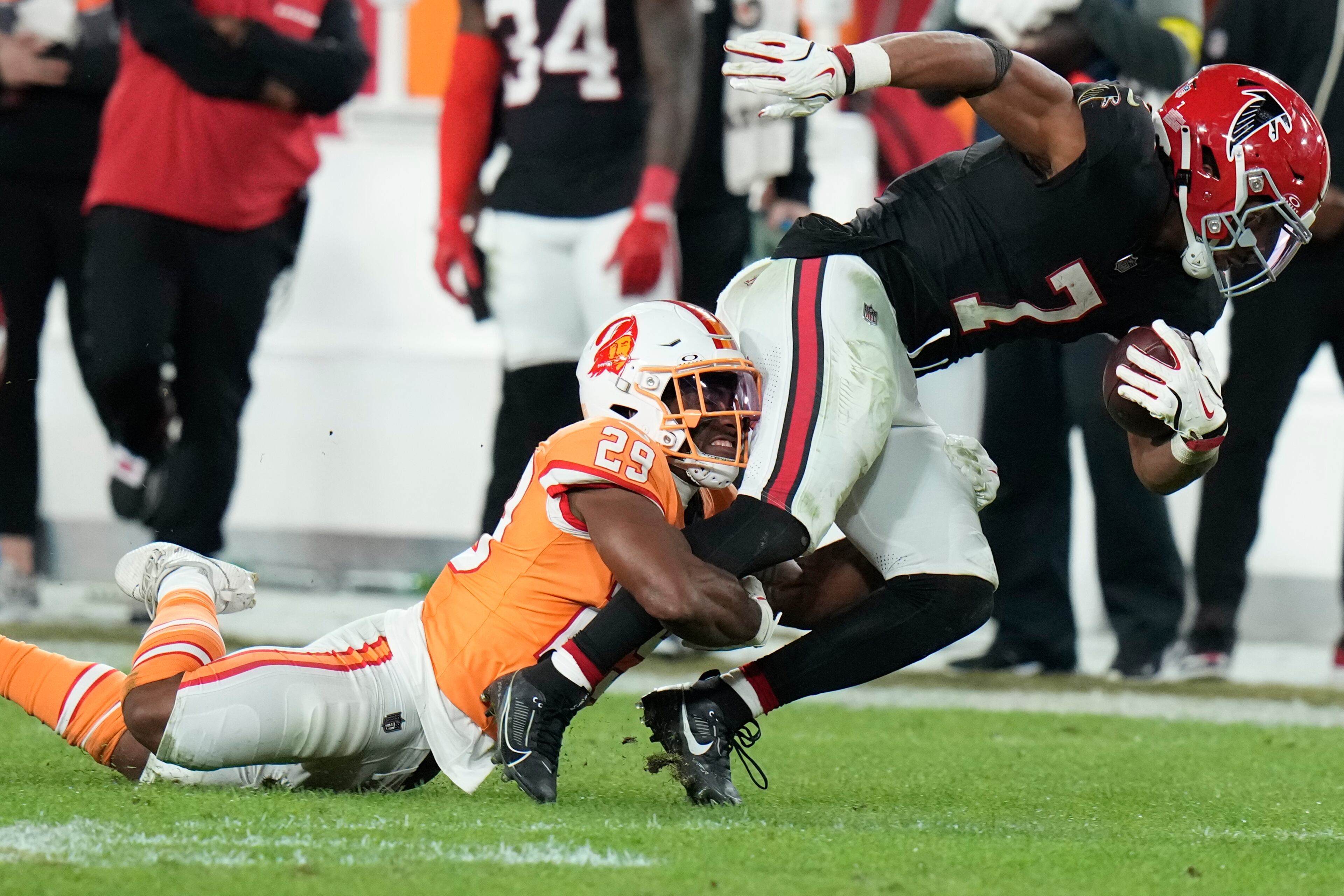 Tampa Bay Buccaneers safety Christian Izien (29) tackles Atlanta Falcons running back Bijan Robinson (7) during the second half of an NFL football game, Thursday, Dec. 11, 2025, in Tampa, Fla. (AP Photo/Chris O'Meara)