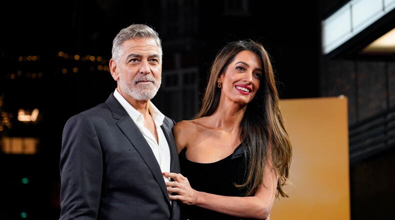 FILE - George Clooney and his wife Amal Clooney pose for photographers upon arrival at the screening of the film "The Boys In The Boat," Dec. 3, 2023, in London. (Photo by Alberto Pezzali/Invision/AP, File)