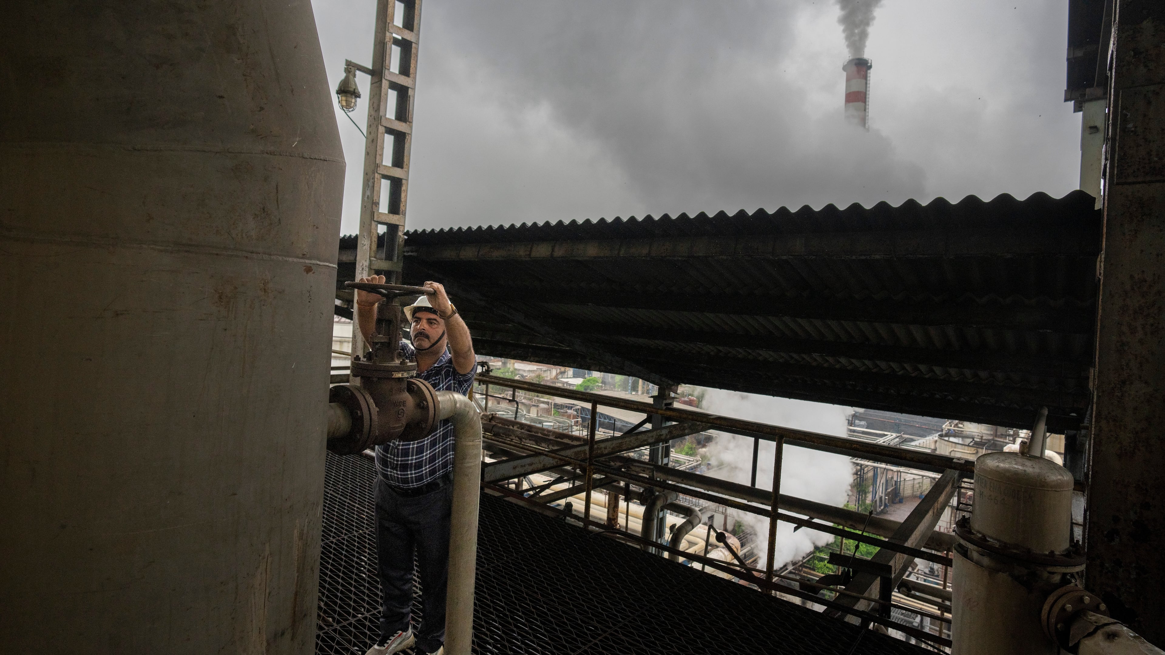 FILE - A technician releases a valve of a tank at Bajaj Hindustan Sugar factory that produces ethanol, a type of biofuel, in Meerut, India, Aug. 23, 2023. (AP Photo/Altaf Qadri, File)