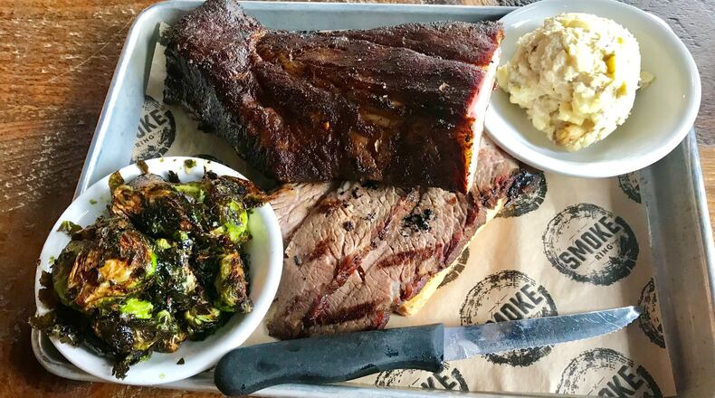 Smoke Ring offers various barbecue plates. Pictured is a plate with a half-rack of baby back ribs (top) and sliced brisket, and side dishes of potato salad and barbecue Brussels sprouts. LIGAYA FIGUERAS / LFIGUERAS@AJC.COM